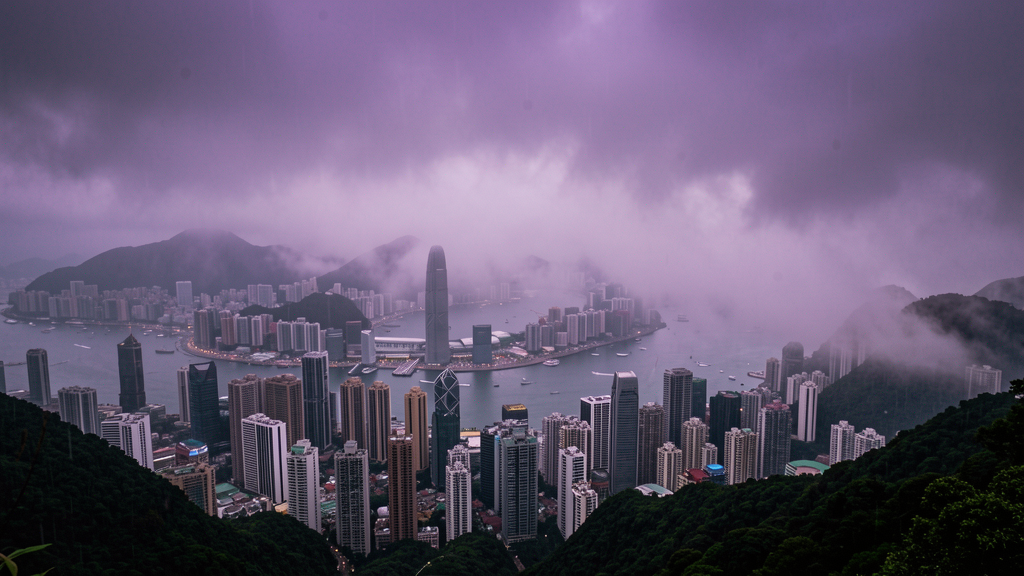 Dramatic moody Hong Kong skyline from Victoria Peak in rainy season mist